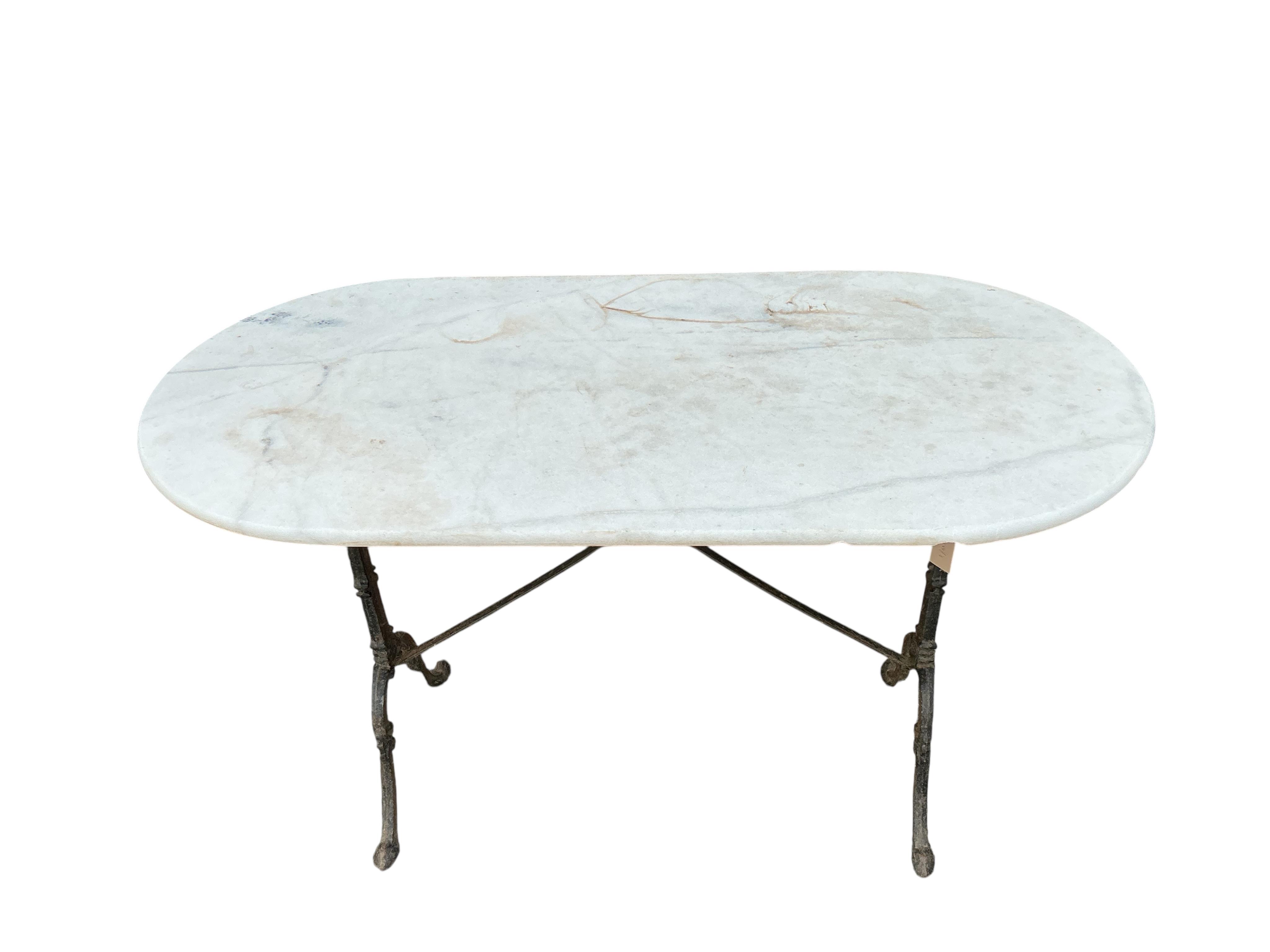 An oval reconstituted marble and cast iron garden table, width 120cm, depth 60cm, height 71cm